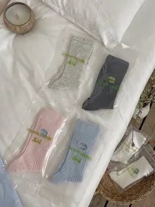 Detailed view of pastel ribbed cotton socks in individual zipper bags with floral decor