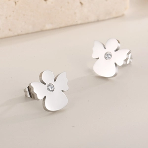 Macro shot of silver angel stud earrings with white cubic zirconia on a stone base