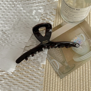 Detailed macro view of handmade chocolate acetate hair claw clip with gold spring