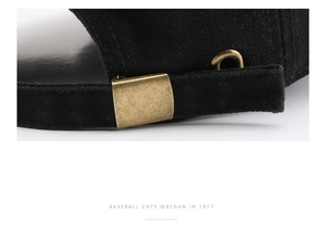 Detail of adjustable vintage metal buckle on black washed cotton baseball cap