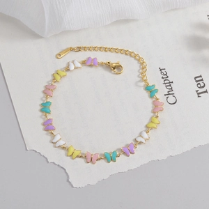 18K gold plated stainless steel bracelet with colorful enamel butterflies on white fabric