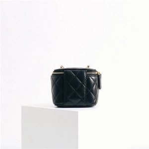 Detail of black quilted leather mini pouch featuring golden zipper and D-ring buckle