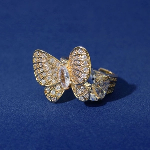Elegant gold butterfly open ring with sparkling zircon stones on a deep blue surface