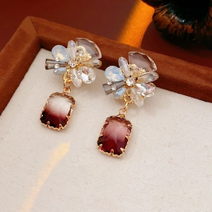Detail of flower-shaped stud with a gradient burgundy rectangle stone earring