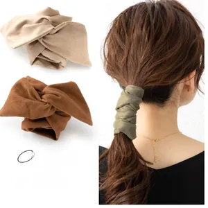 Detail of soft suede-like bow hair wraps in beige, green, coffee, navy and wine red colors