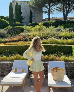 Detail of light yellow striped cotton shirt and matching pleated shorts for vacation