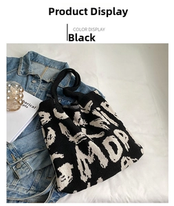 Detail of black and white knitted tote bag with jacquard letter patterns and soft handles