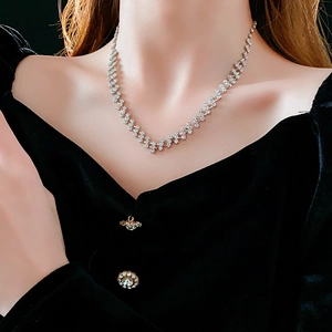 Detail of silver geometric link necklace with sparkling stones on a female model