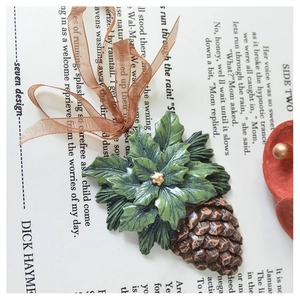 Detailed close-up of a vintage resin Christmas tree ornament with pinecone on open book