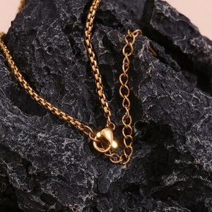 Macro detail of 18K gold plated box chain necklace with lobster clasp and extender