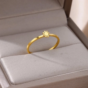 Macro shot of minimalist gold plated stainless steel sun patterned ring in a velvet box