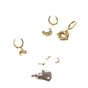 Golden moon and heart earrings set with blue zircon dangles on a white background
