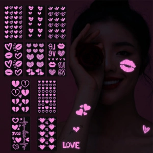 Im Dunkeln leuchtende rosa Herz- und Schmetterling-Tattoos in dunkler Umgebung