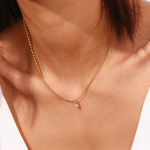 Primo piano della collana a catena con perline placcata oro 18K e pendente in zircone