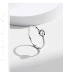 Close-up of S925 sterling silver stamp and heart-shaped moissanite on a minimalist ring