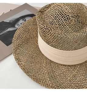 Macro view of hand-woven straw hat detail with breathable hollow mesh and beige ribbon