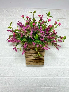 Close-up of artificial pink berries and wildflowers in a rustic woven hanging basket