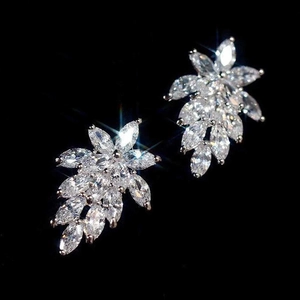 Macro shot of marquise-cut cubic zirconia leaf earrings set in silver metal on black background