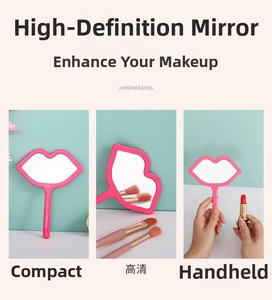 Pink lip-shaped hand-held makeup mirror with compact handle for portable use