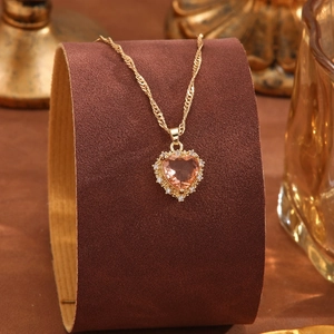 Detail von pfirsichfarbenem Herz-Kristallanhänger mit Zirkonia auf goldener Kette