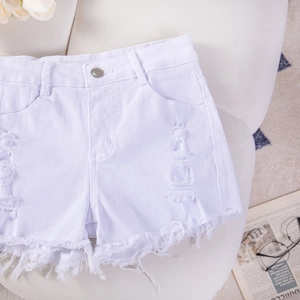 Primo piano di pantaloncini di jeans bianchi strappati con bordi sfilacciati su sfondo
