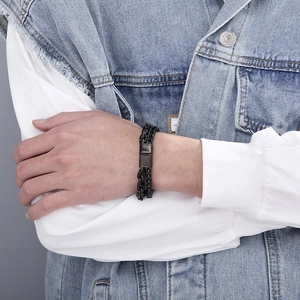 Close-up of black braided cord bracelet with dark grey magnetic metal clasp for men