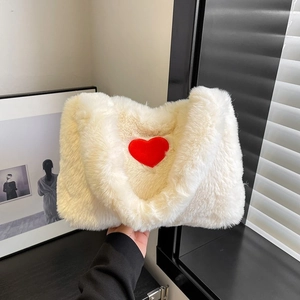 Detail of soft white plush handbag featuring a vibrant red heart-shaped embroidery