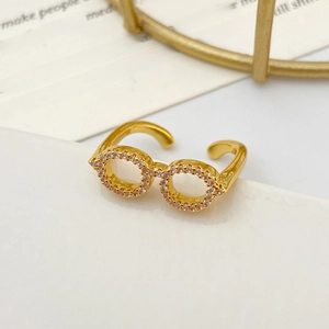 Detailed close-up of a gold glasses-shaped ring with pave-set sparkling white zircons