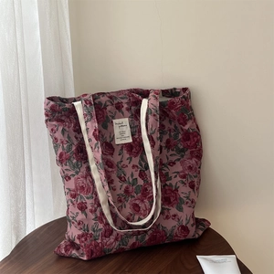 Détail du jacquard floral rose rouge vintage sur le sac à bandoulière en toile