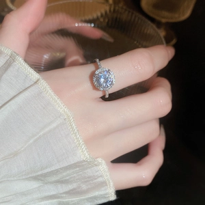 Macro detail of silver halo ring with zircon pavé setting on a feminine hand