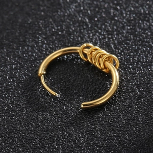 Minimalist gold hoop earrings with five small dangling rings on a textured black surface