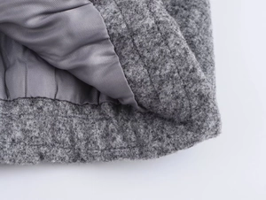 Macro detail of grey pilot jacket showing textured wool fabric and smooth inner lining