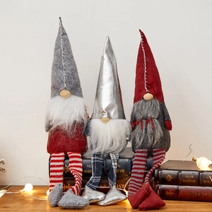 Three Christmas gnomes with long legs sitting on books in a festive home setting