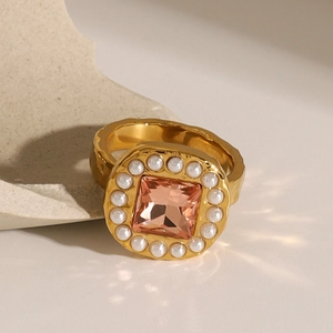 18k vergoldeter Edelstahlring mit orangefarbenem Edelstein und Perlenrand auf Stein