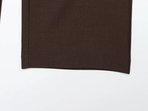 Gros plan détaillé du tissu sergé marron foncé montrant les coutures de qualité