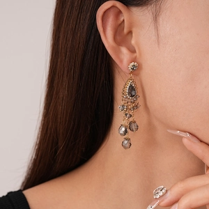 Boucles d'oreilles vintage dorées avec perles en cristal gris fumé sur mannequin