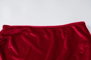 Gros plan d'une robe en velours rouge montrant les coutures et la texture du tissu