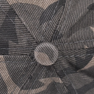 Gros plan du tissu sergé camouflage et des surpiqûres sur le dessus de la casquette