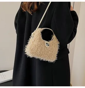 Close-up of beige faux shearling handbag with silver metal lock and black coat background