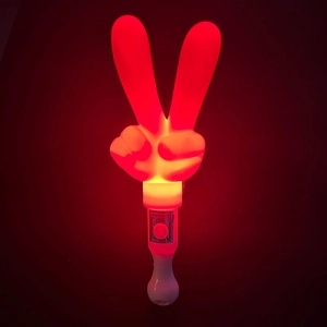 Detail of hand-shaped LED glow stick showing bright red light and operation switch