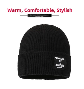 Detail of a black ribbed knit beanie featuring a stitched woven label with white text