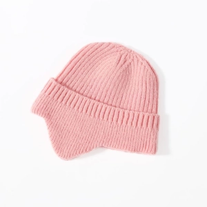 Close-up of pink knitted winter hat showing soft yarn texture and ear protection design