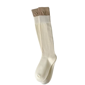 Cream white knee high socks with brown trim featuring minimalist knitted texture