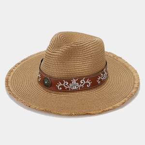 Macro shot of embroidered floral ribbon and turquoise buckle on straw sun hat