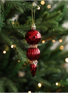 Close-up of burgundy Christmas ornaments with textured patterns on a festive green tree