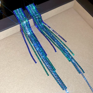 Macro shot of elegant silver-plated square tassel earrings with blue gradient crystals