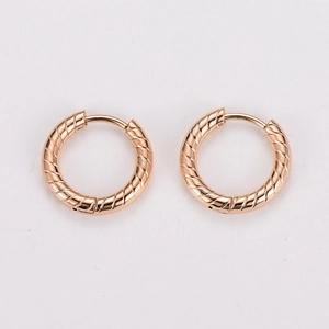 Detailed view of rose gold round hoop earrings with textured woven diagonal pattern