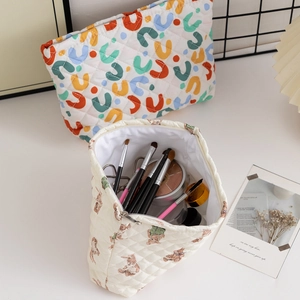 Quilted floral makeup bag with teddy bear pattern and zipper showing internal storage