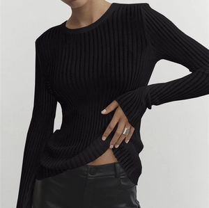 Detailed view of the rib-knit texture on a black long sleeve slim-fit crewneck top