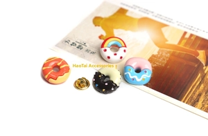 Detailed view of four colorful donut enamel pins with metal butterfly clasps